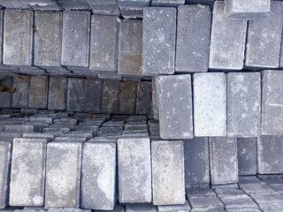 High-quality stack of durable concrete paving blocks in an outdoor storage yard, ready for shipment to road construction sites. 