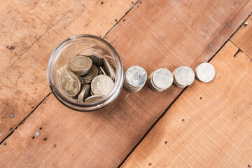 Glass jar filled with coins with a yellow lid and coin growth with a solid bottom