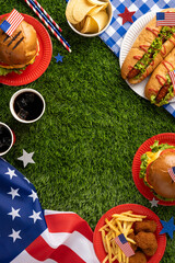 Labor Day or Independence Day celebration featuring a picnic vertical setup with classic American food items like burgers, hotdogs, fries, and patriotic elements against a grass background