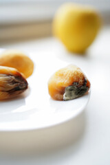 rotten fruits on a light background, apricot and apple