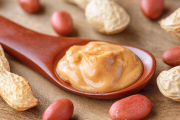 Closeup view of wooden spoon of tasty peanut butter
