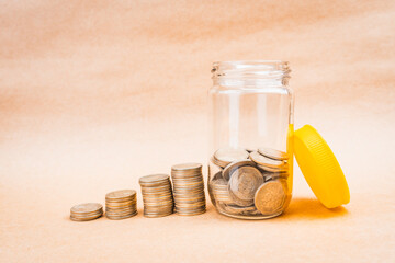 Glass jar filled with coins with a yellow lid and coin growth with a solid bottom