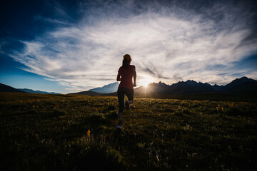 Runner running on the high altitude grassland mountain top trail