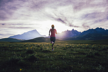 Runner running on the high altitude grassland mountain top trail
