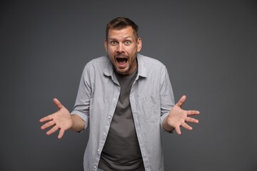 Man suffering from panic attack on grey background