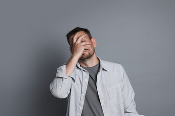 Man suffering from hangover on grey background