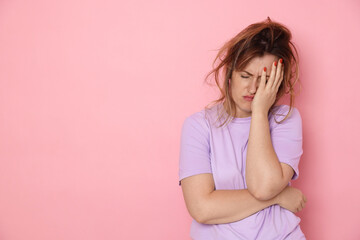 Woman suffering from hangover on pink background. Space for text
