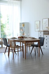 Beautiful table setting, chairs and decor in dining room. Interior design