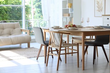 Beautiful table setting, chairs and decor in dining room. Interior design