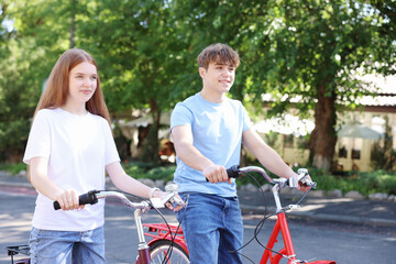 Obraz premium Teenage girl and boy riding bicycles on city street