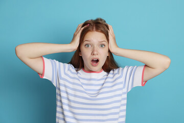 Teenage girl suffering from panic attack on light blue background