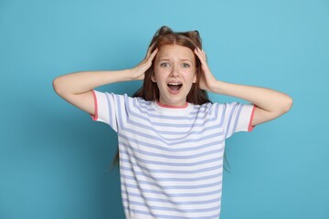 Teenage girl suffering from panic attack on light blue background