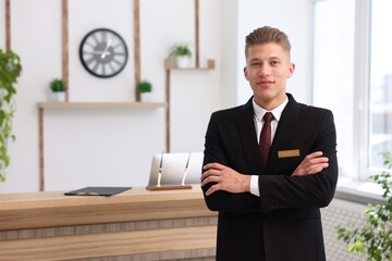 Portrait of smiling receptionist with crossed arms in hotel