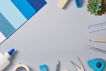Top view of the paper crafts work table. Scissors, craft knife, pencil, glue, eraser, paper. Place for your text.