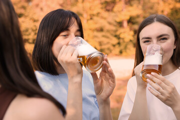 Group of happy friends having fun and drinking beer outdoors