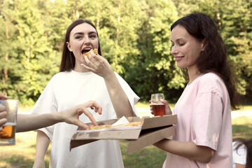 Group of happy friends having fun and drinking beer outdoors