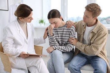 Obraz premium In vitro fertilization (IVF). Doctor supporting upset couple during visit in reproductive clinic