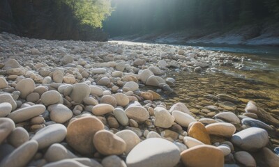 Obraz premium Riverbank strewn with smooth stones, sunlight