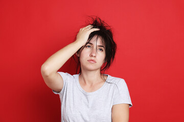 Woman suffering from hangover on red background