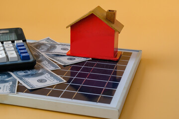 Composition with solar panel, led lamp, money and model house on texture background.