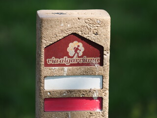 The picture shows a signpost for the Via Algarviana, a long-distance hiking trail in the Algarve,...