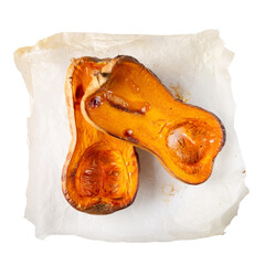Roasted butternut squash halves on baking paper isolated on white background. Top view.