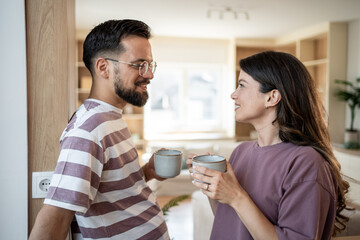 Happy couple enjoying morning coffee together at home
