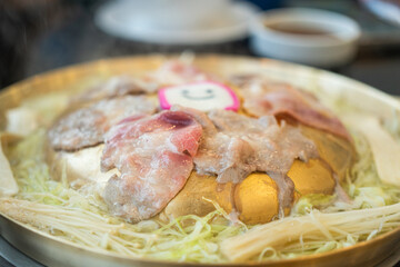 Sliced piece of pork meat was grilling on BBQ pan. Food cooking with object photo, close-up and selectice focus.