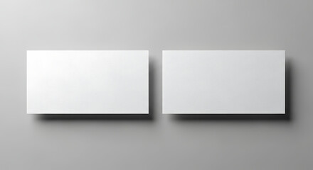 Blank white business cards on a grey background, perfect for a professional, minimalist presentation or customizable template to showcase your brand identity and design concepts.