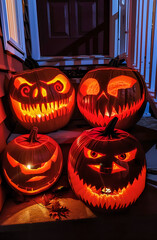 Glowing Halloween pumpkins with scary carved faces on a porch at night. Spooky jack o’ lantern decoration perfect for autumn, holiday, and festive seasonal design.