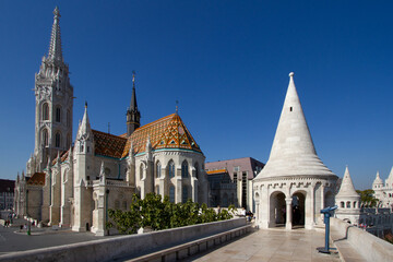Historic Church and Tower with Ornate Roof Against Clear Blue Sky