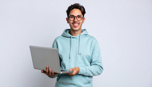 Young businessman with glasses smiling while using a laptop in a casual office setting - Powered by Adobe