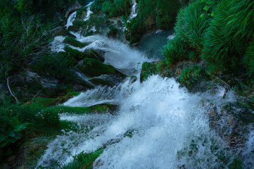 Clear sparkling water with waterfalls and water droplets splashing at Plitvice Lakes, Croatia,...
