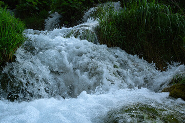 Clear sparkling water with waterfalls and water droplets splashing at Plitvice Lakes, Croatia, Europe.