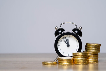 An alarm clock beside stacks of gold coins, symbolizing the relationship between time and money...