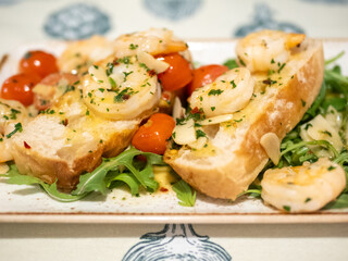 Plate of shrimp and tomato salad with bread on the side