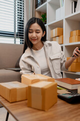 an entrepreneur is packing parcel for order from customer, she own a small business, sme, a lot of...