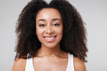 Beautiful Brazilian woman with healthy skin on gray background