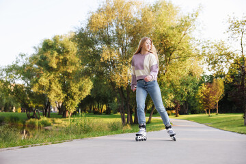 Happy young woman roller skating in park