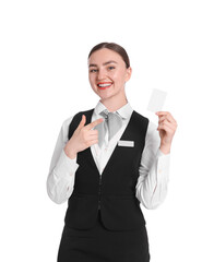 Smiling receptionist in uniform pointing at hotel key card on white background