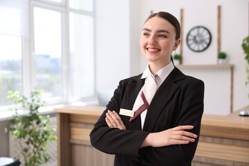 Portrait of smiling receptionist with crossed arms in hotel