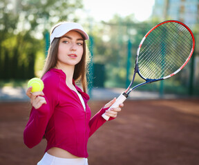 Beautiful woman with racket and ball at tennis court