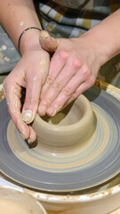 Hands crafting clay pot on pottery wheel ceramic art process