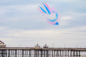 Blackpool, England - 10th August 2025: The Red Arrows performing an aerial display using red, white and blue smoke over the North Pier as part of the Blackpool Air Show