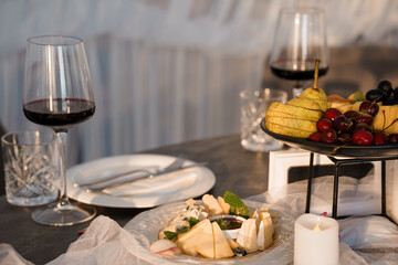 Romantic Wine and Cheese Pairing: Two Glasses, Fruits, Candlelight, Dark Wood Table, Fine Dining,...