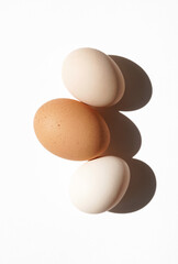 Closeup of Farm Eggs in Beige and Brown Colours on White Background. Breakfast Eggs Cooking.                      