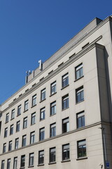 Urban architecture showcasing a modern multi-story building under clear blue sky during daytime in a vibrant city setting