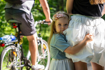 Eye level portrait of child hugging mother in park revealing family bonding. Adorable little girl...