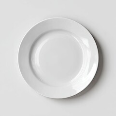 Overhead view of a clean, simple, round, white dinner plate on a light gray background; subtly shadowed