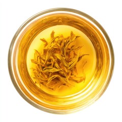 Overhead view of a clear glass cup containing light amber tea infused with dried, pale yellow, curled tea leaves